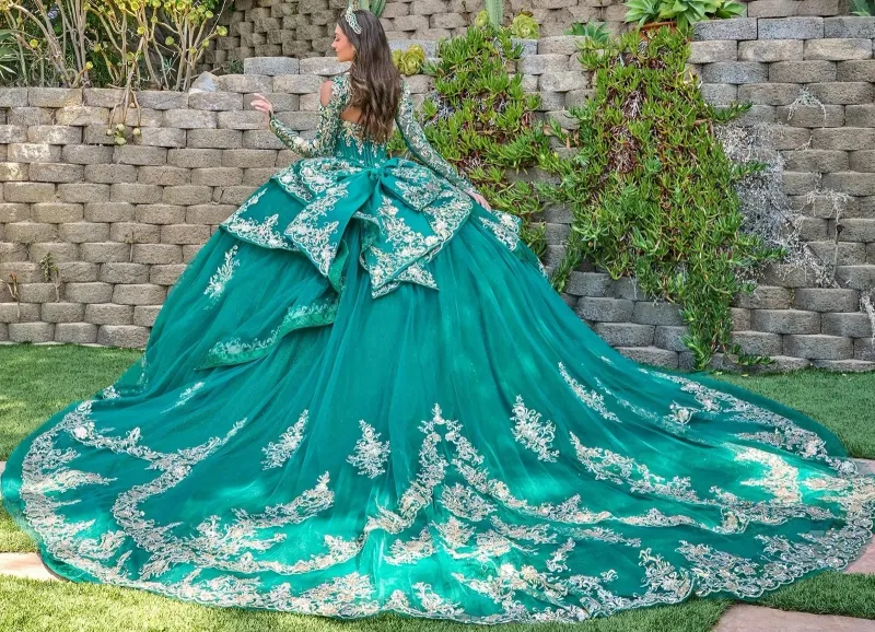 Vestido de 15 años imperial de manga larga con apliques dorados y pedrería, falda corte Princesa con cola y lazo