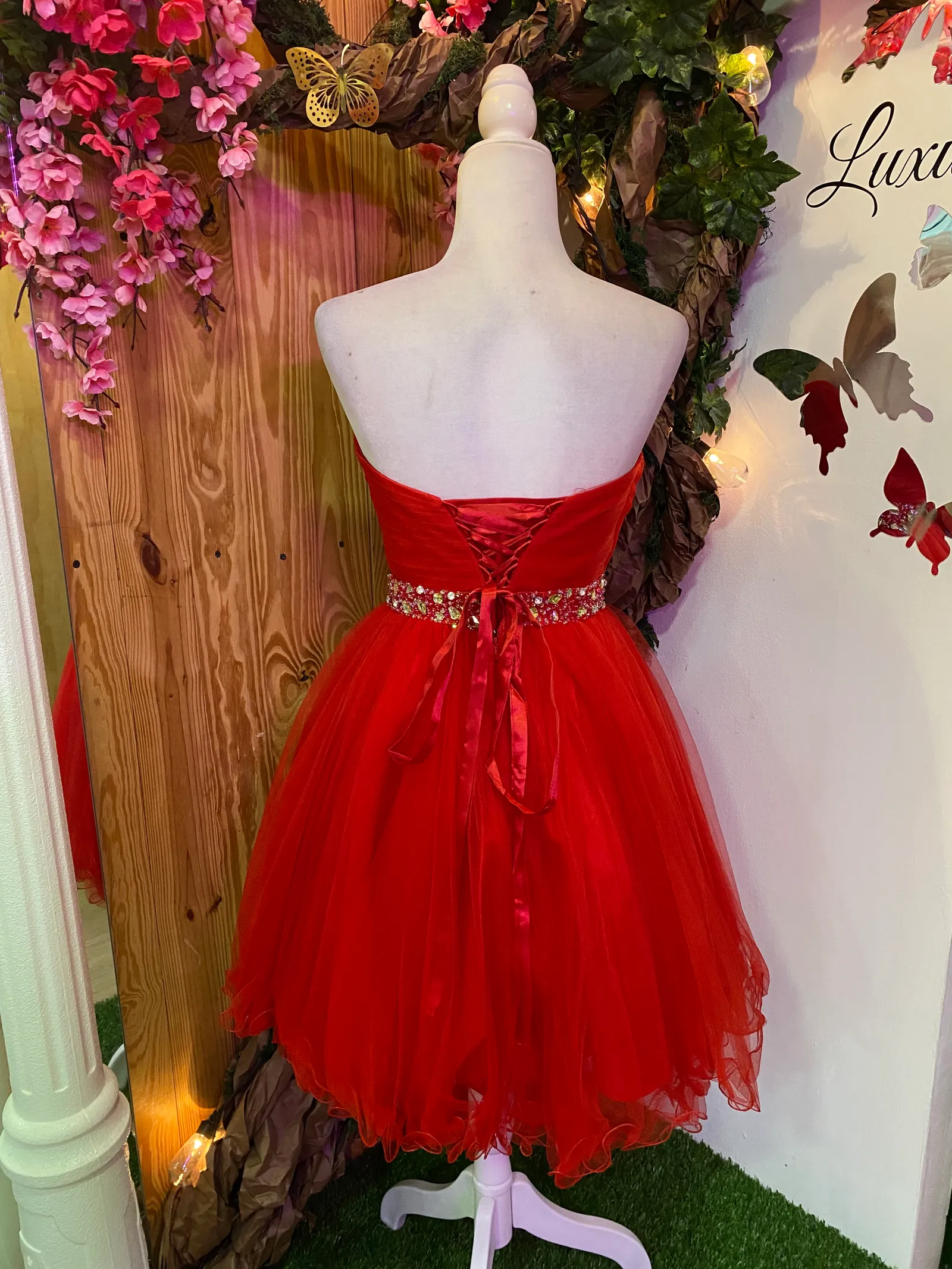 Vestido de Quinceañera corto Strapless con decoraciones de Pedreria en cintura y falda corte A de Vuelos
