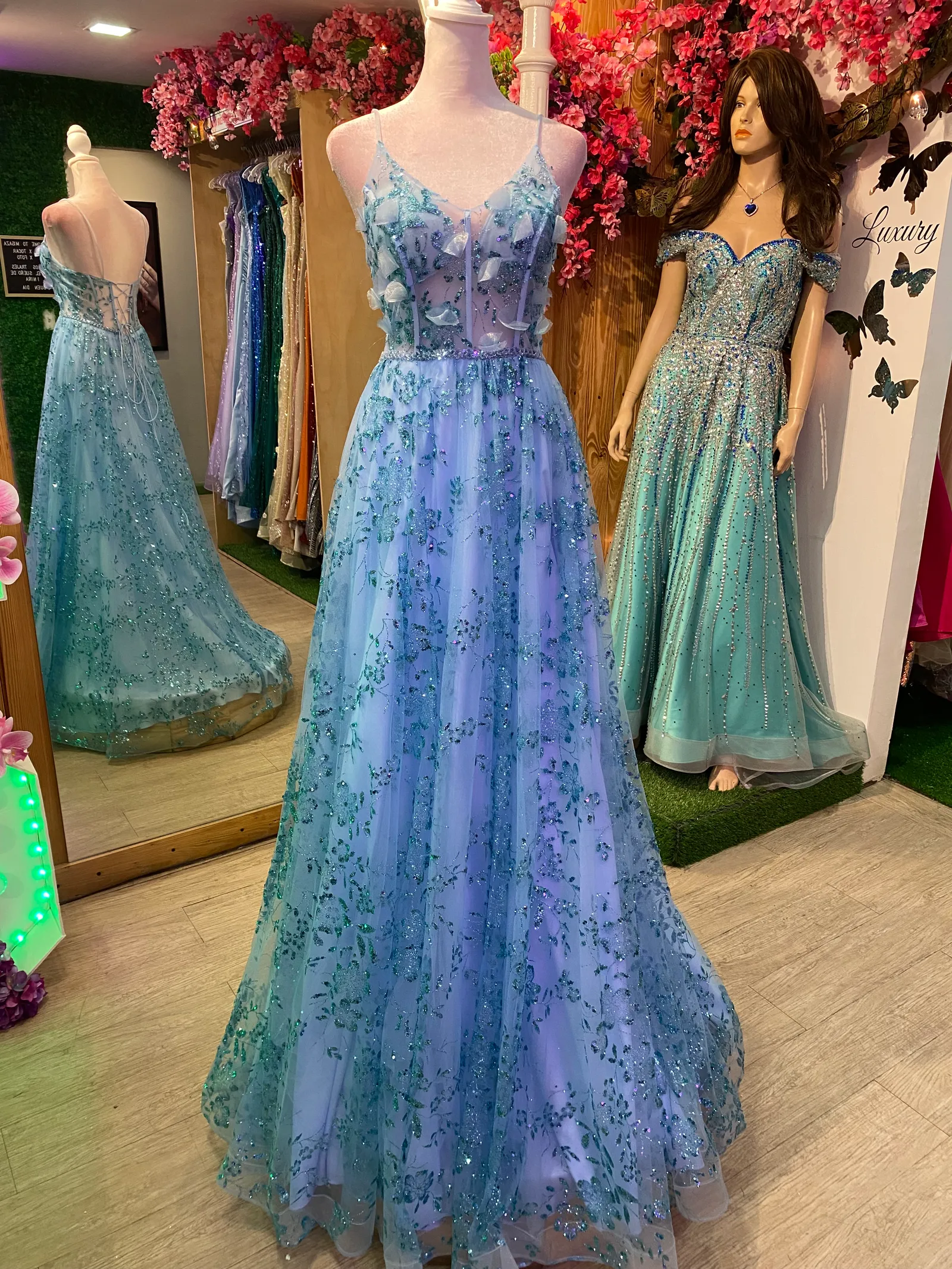 Vestido de Gala de tiras estilo corset con transparencia color Celeste decorado con decoraciones en glitter y petalos en 3D