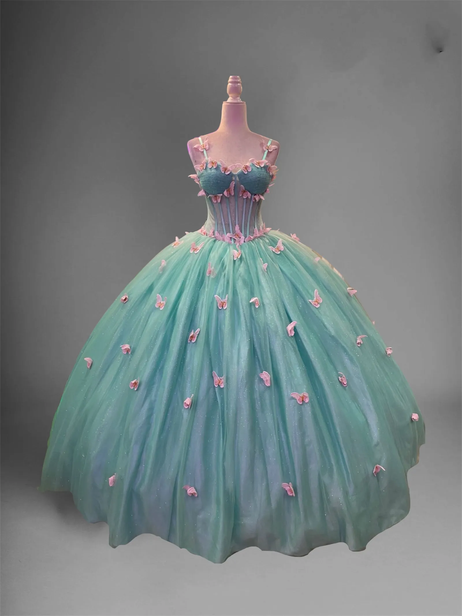 Vestido de 15 años de tiras, estilo corset con transparencia decorado con Glitter y apliques de mariposas en 3D