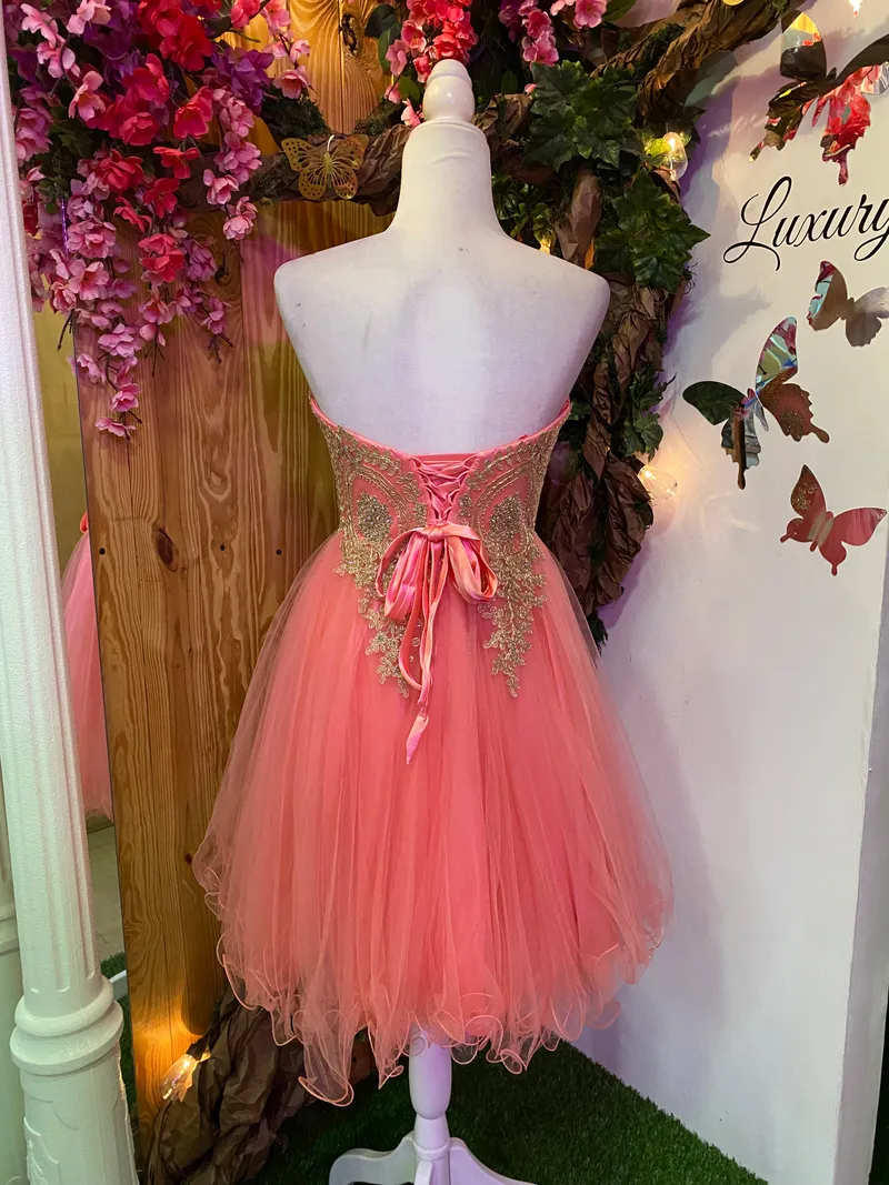 Vestido corto de Quinceañera Strapless decorado con apliques dorados en Top y falda corte A de Tul