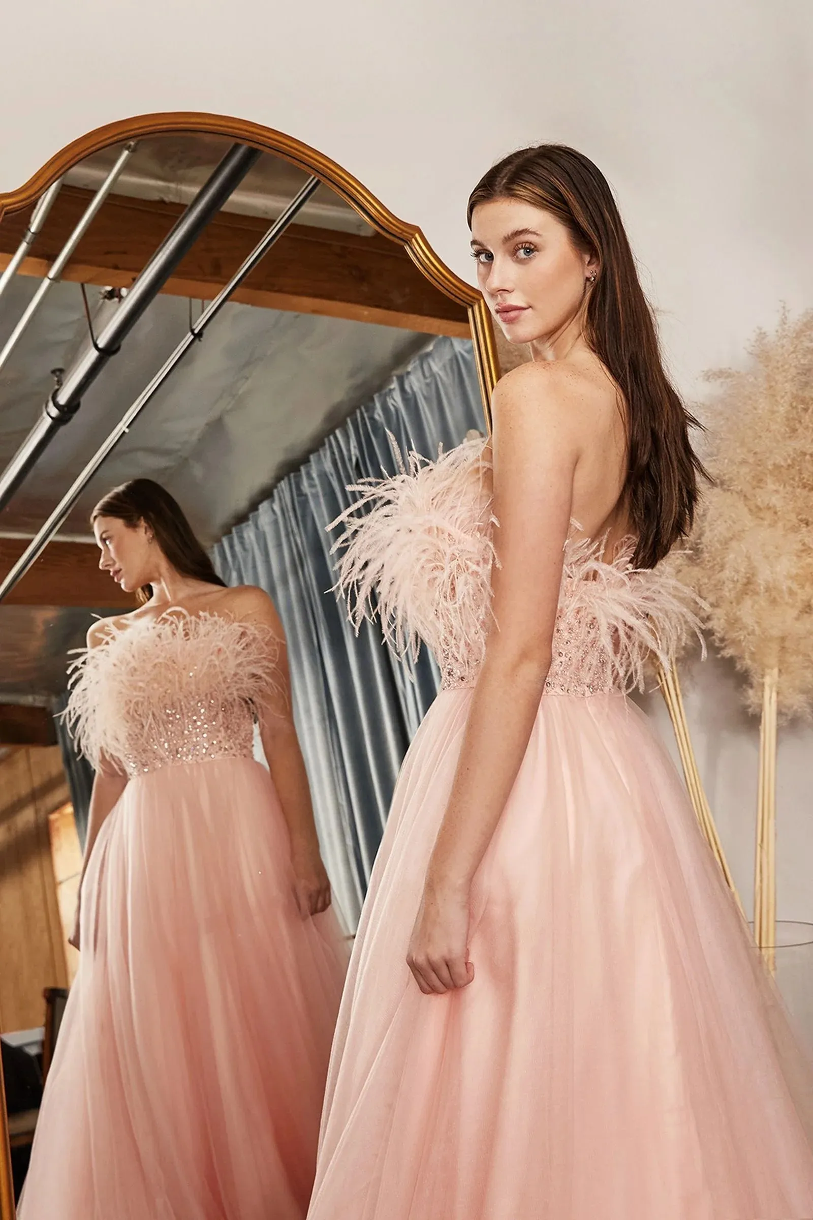 Vestido de gala strapless color Blush decorado con plumas y pedreria falda corte A con tull