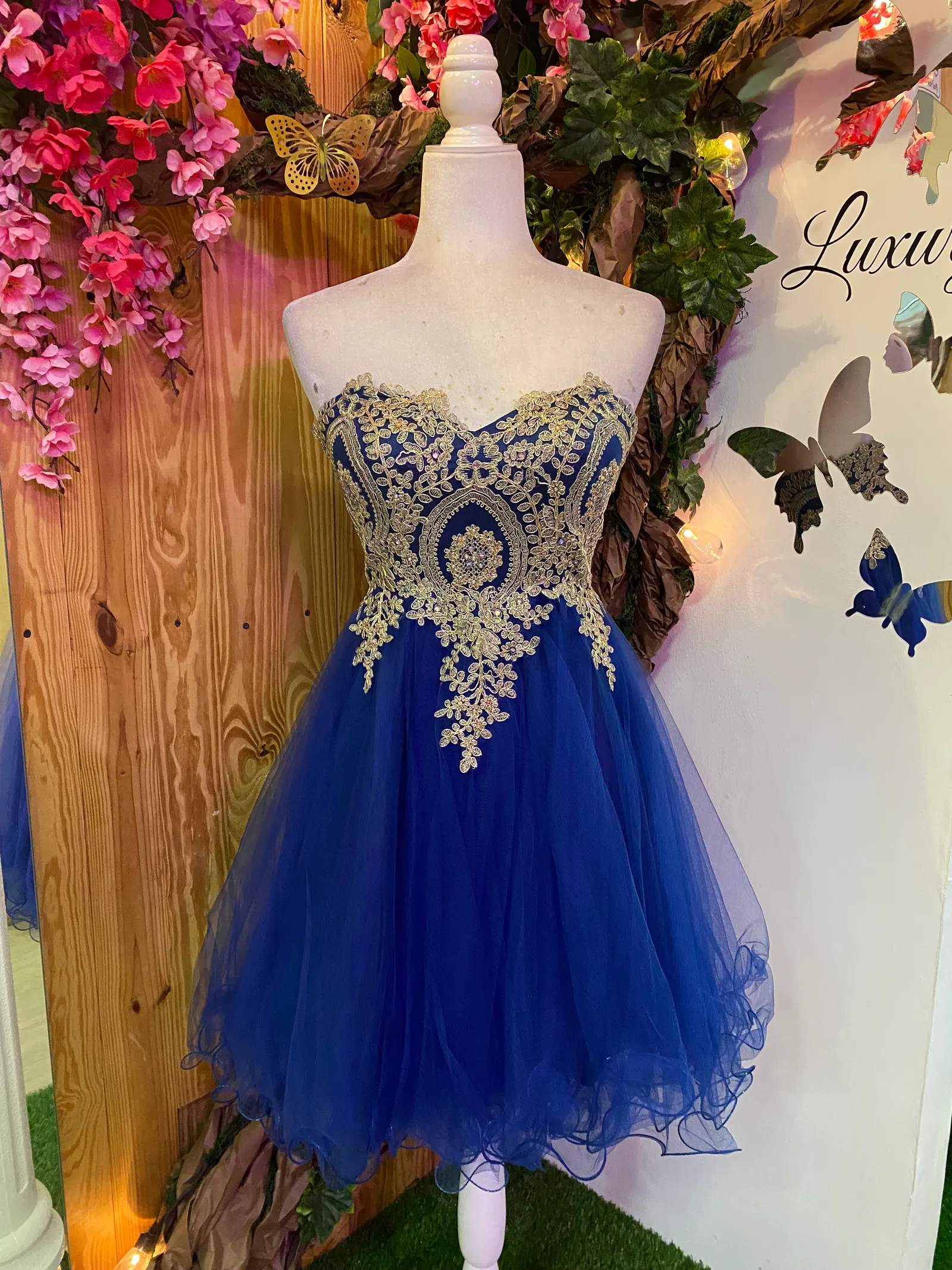 Vestido corto de Quinceañera Strapless decorado con apliques dorados en Top y falda corte A de Tul