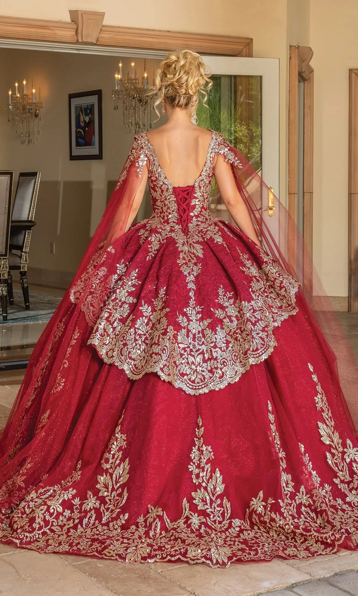Vestido de 15 años decorado con apliques dorados y capas en las mangas