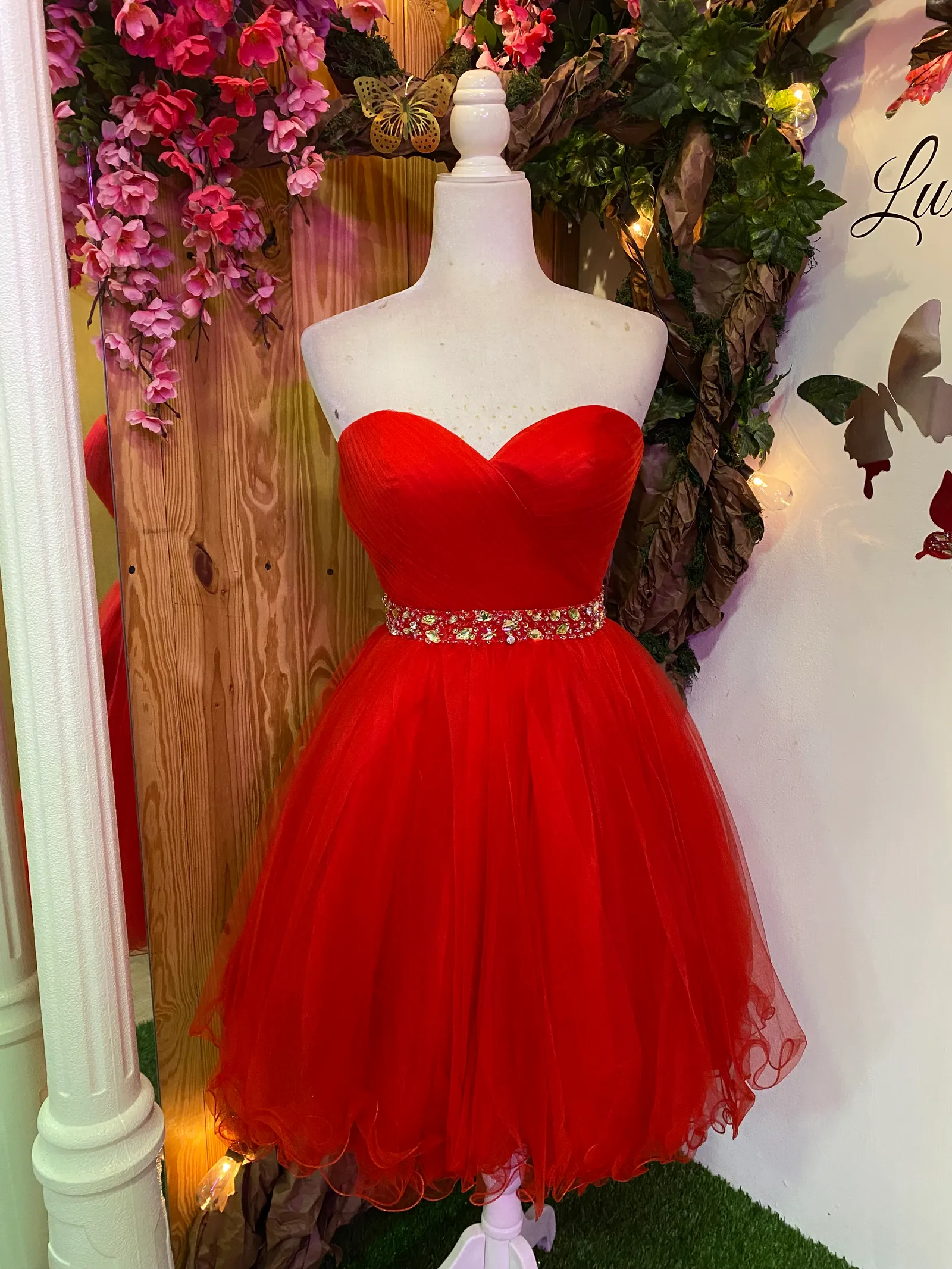 Vestido de Quinceañera corto Strapless con decoraciones de Pedreria en cintura y falda corte A de Vuelos
