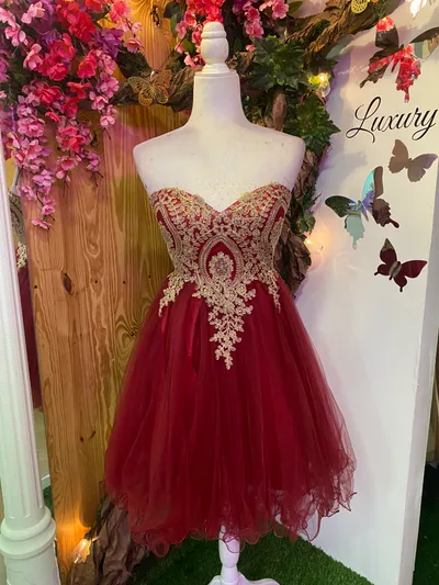 Vestido corto de Quinceañera Strapless decorado con apliques dorados en Top y falda corte A de Tul