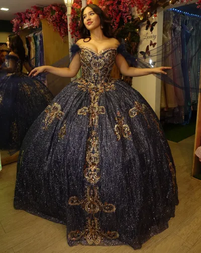 Vestido de 15 años Off Shoulder color Navy decorado con apliques y Glitter en dorado y capas en mangas con plumas