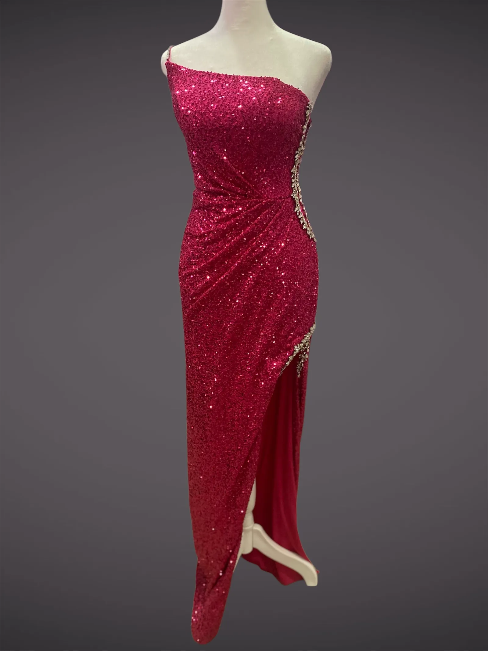 Vestido de gala One Shoulder en tela de lentejuelas color Fucsia decorado con pedreria plateada