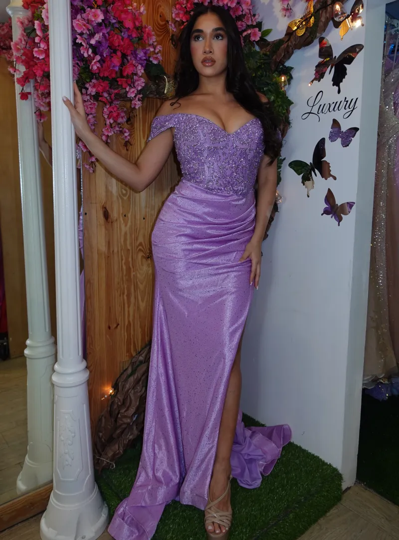 Vestido de Gala Off Shoulder color Lila decorado con pedreria y apliques plateados falda con drapeado y abertura lateral
