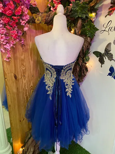 Vestido corto de Quinceañera Strapless decorado con apliques dorados en Top y falda corte A de Tul